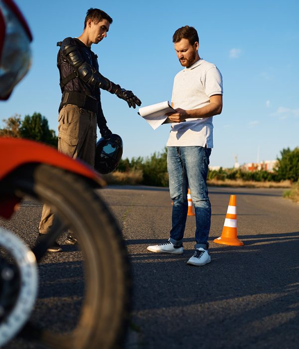 Male student and instructor, skill test in motorcycle school. Training of motorcyclists beginners, biker practicing in motorschool